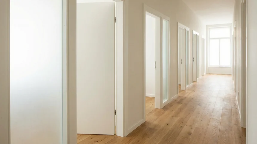 Row of exam lane doorways receding down bright corridor