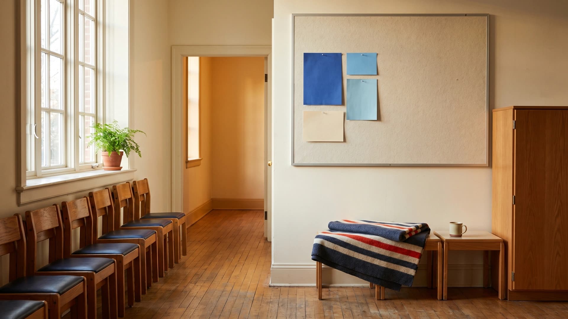 Empty youth-program room with stacked chairs preserved in quiet — abuse and molestation coverage